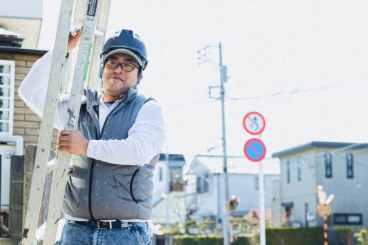 脚立を担ぐ男性