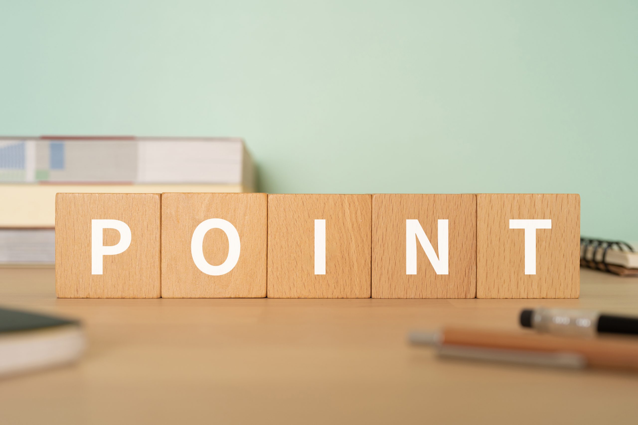 「POINT」と書かれた木製のキューブブロックと文房具